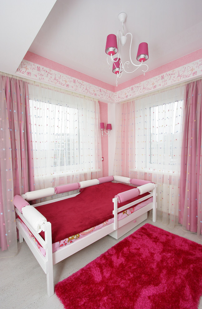 Photo of a large contemporary kids' bedroom for girls in Other with pink walls and light hardwood floors.