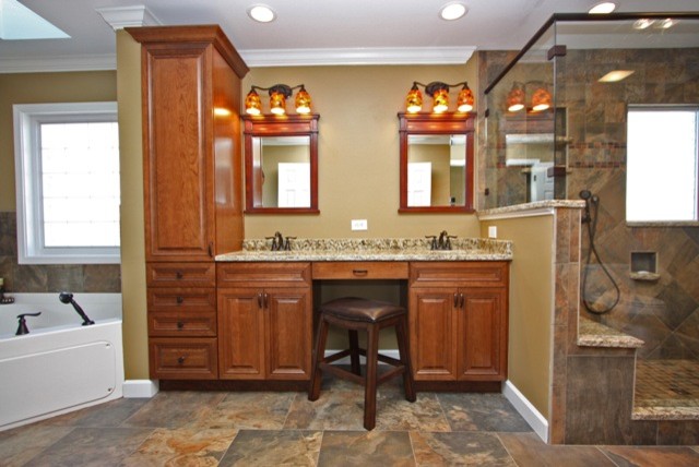 This is an example of a large transitional master bathroom in Raleigh with an undermount sink, beaded inset cabinets, medium wood cabinets, granite benchtops, a corner tub, a double shower, a one-piece toilet, multi-coloured tile, porcelain tile, orange walls and porcelain floors.