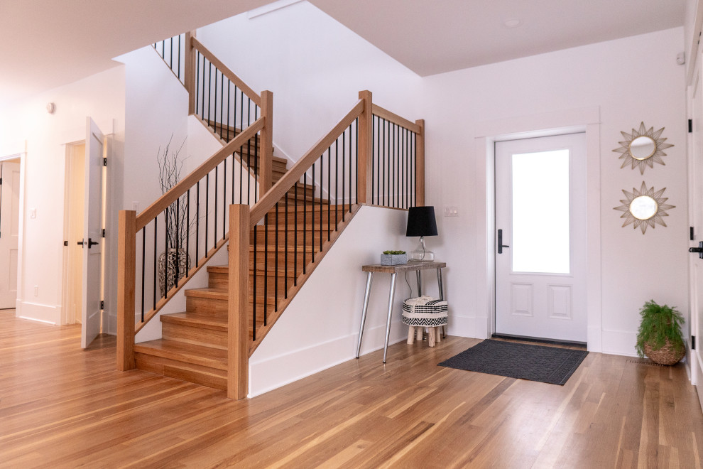 Transitional medium tone wood floor and multicolored floor single front door photo with white walls and a metal front door