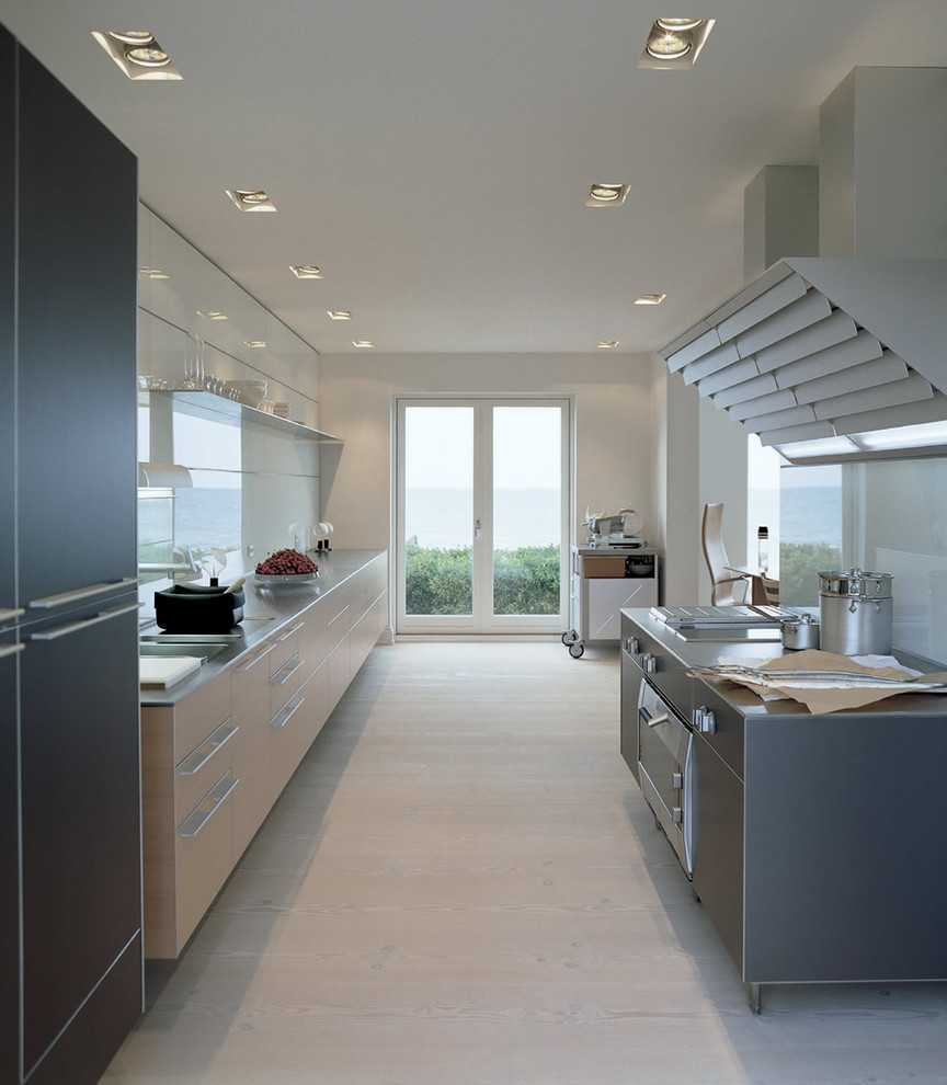 Design ideas for a large contemporary kitchen in London with flat-panel cabinets, light wood cabinets, white splashback, glass sheet splashback, panelled appliances and light hardwood floors.