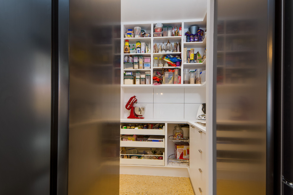 Modern galley kitchen pantry in Melbourne with mirror splashback and with island.