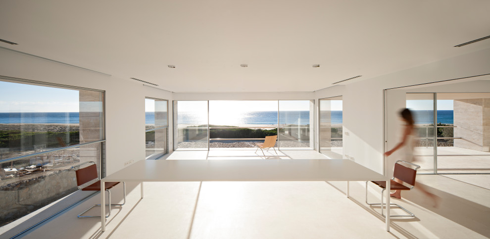 Immagine di un grande soggiorno costiero aperto con pareti bianche e pavimento bianco