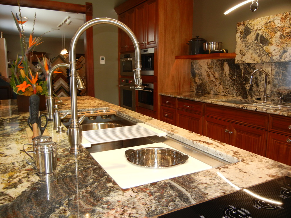Example of a transitional open concept kitchen design with an undermount sink, raised-panel cabinets, medium tone wood cabinets, granite countertops, stone slab backsplash, stainless steel appliances and an island