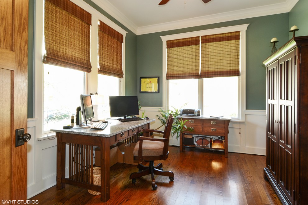This is an example of a mid-sized arts and crafts study room in Chicago with blue walls, dark hardwood floors, no fireplace and a freestanding desk.