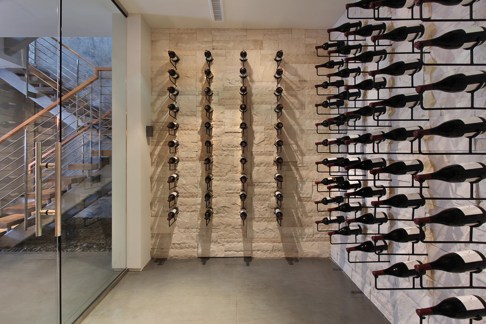 Inspiration for a contemporary wine cellar in Orange County with concrete floors, storage racks and grey floor.