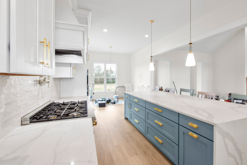 Example of a large transitional l-shaped open concept kitchen design in Richmond with a farmhouse sink, recessed-panel cabinets, quartz countertops, white backsplash, stainless steel appliances, an island and white countertops