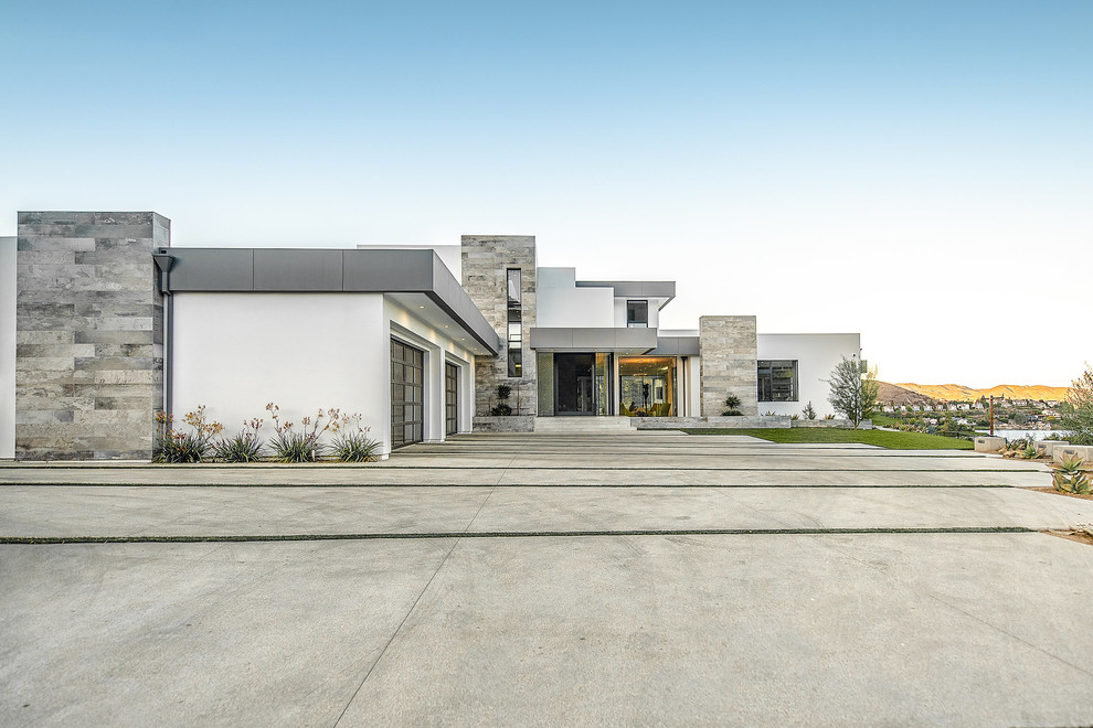 Design ideas for an expansive contemporary two-storey stucco white house exterior in Los Angeles with a flat roof.