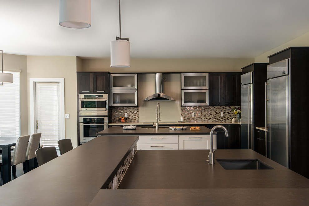 Large transitional eat-in kitchen in Detroit with an undermount sink, flat-panel cabinets, dark wood cabinets, quartzite benchtops, metallic splashback, glass sheet splashback, stainless steel appliances and multiple islands.