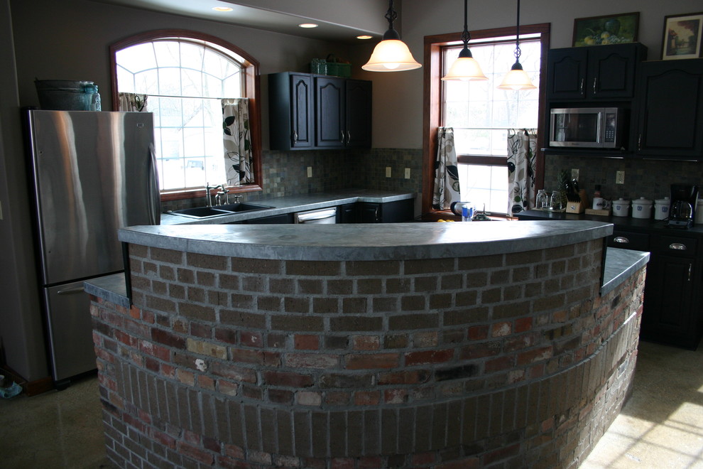 Example of a mid-sized transitional l-shaped concrete floor eat-in kitchen design in Orange County with a double-bowl sink, shaker cabinets, black cabinets, concrete countertops, multicolored backsplash, stone tile backsplash, stainless steel appliances and an island