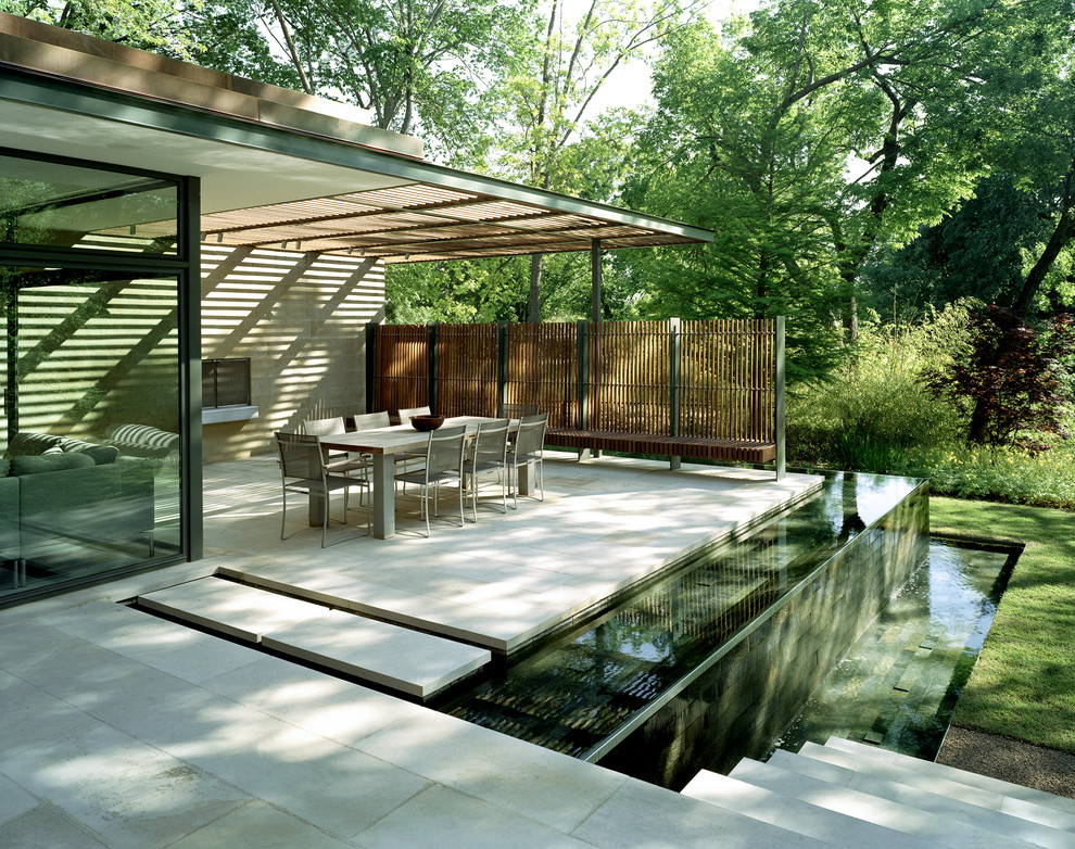 Photo of a contemporary patio in Dallas with a water feature, concrete pavers and a pergola.