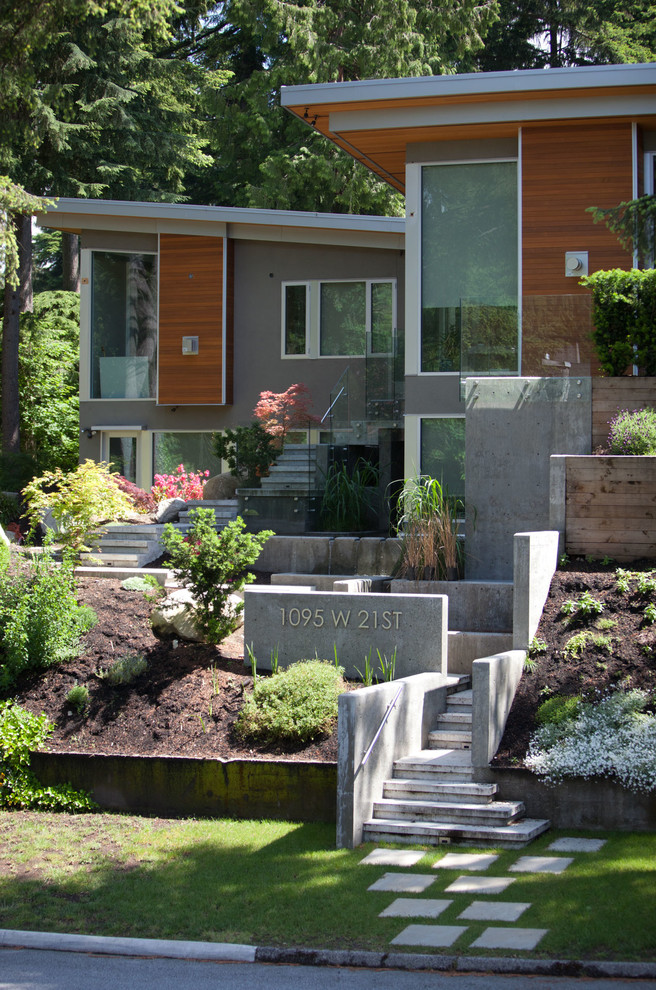 Photo of a contemporary two-storey brown exterior in Vancouver with mixed siding.