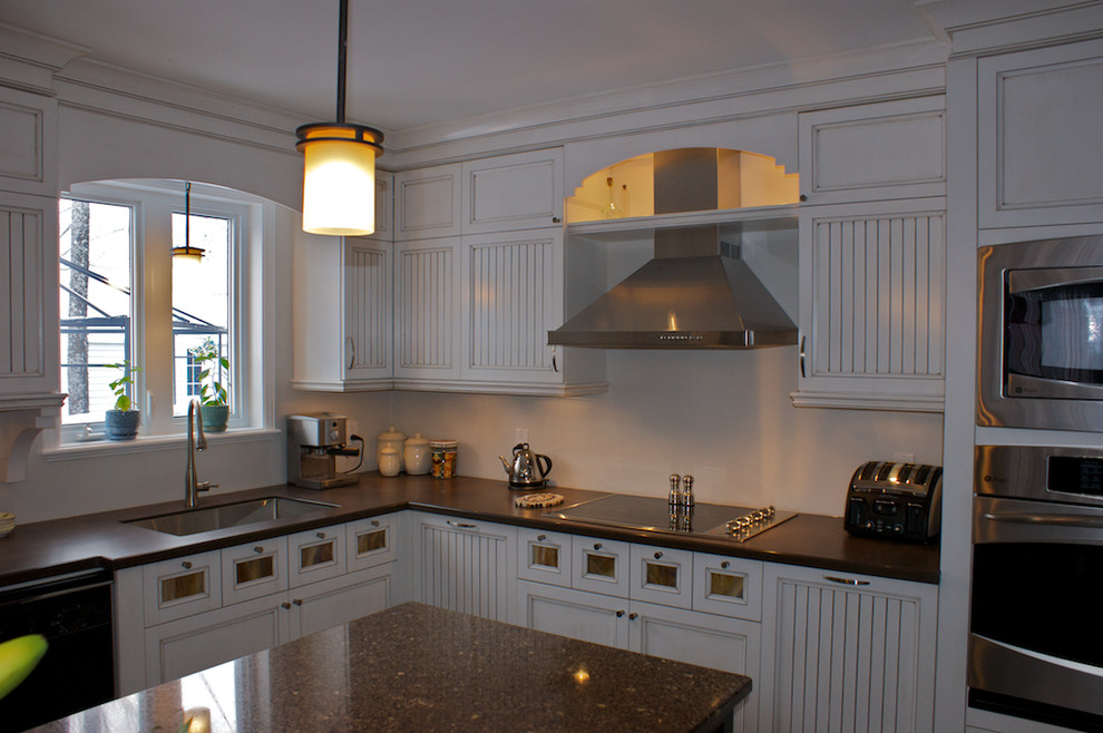 Mid-sized cottage porcelain tile and beige floor enclosed kitchen photo with an undermount sink, shaker cabinets, white cabinets, quartz countertops, beige backsplash, ceramic backsplash, stainless steel appliances and an island