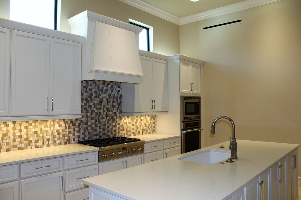 Eat-in kitchen - large transitional galley porcelain tile eat-in kitchen idea in Tampa with an undermount sink, recessed-panel cabinets, white cabinets, quartz countertops, multicolored backsplash, stone tile backsplash, stainless steel appliances and an island