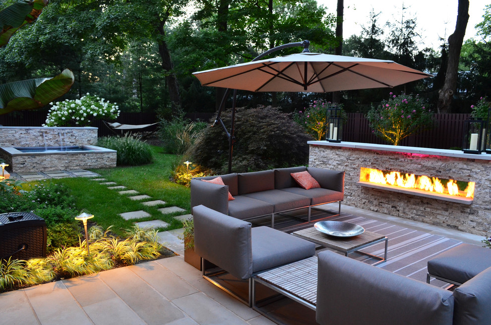 Inspiration for a transitional backyard patio in New York with with fireplace.