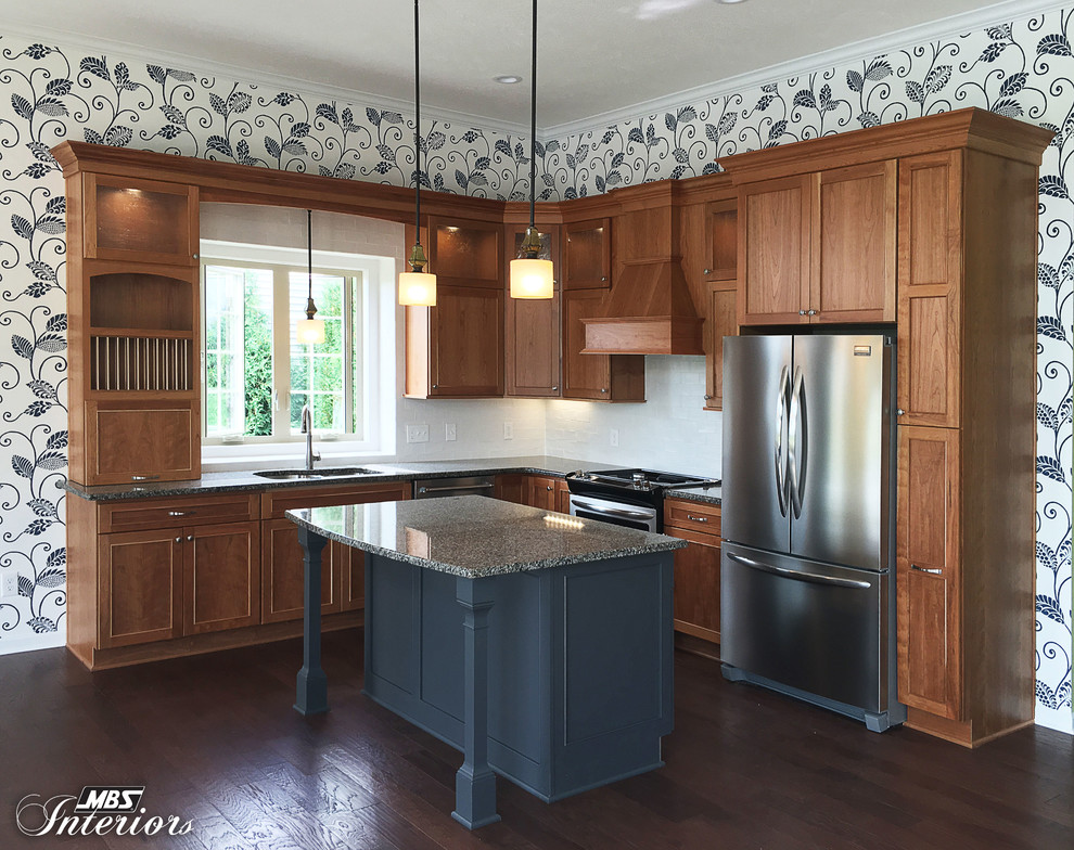 Example of a mid-sized transitional l-shaped dark wood floor and brown floor eat-in kitchen design with an undermount sink, recessed-panel cabinets, medium tone wood cabinets, granite countertops, white backsplash, ceramic backsplash, stainless steel appliances and an island