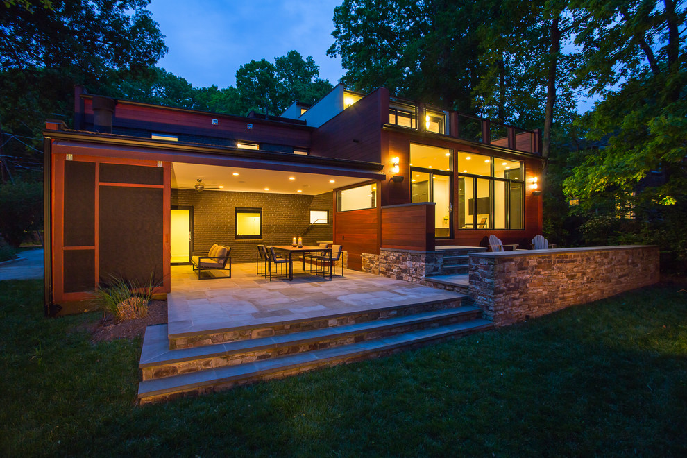 Large contemporary backyard patio in DC Metro with a fire feature, concrete pavers and a roof extension.