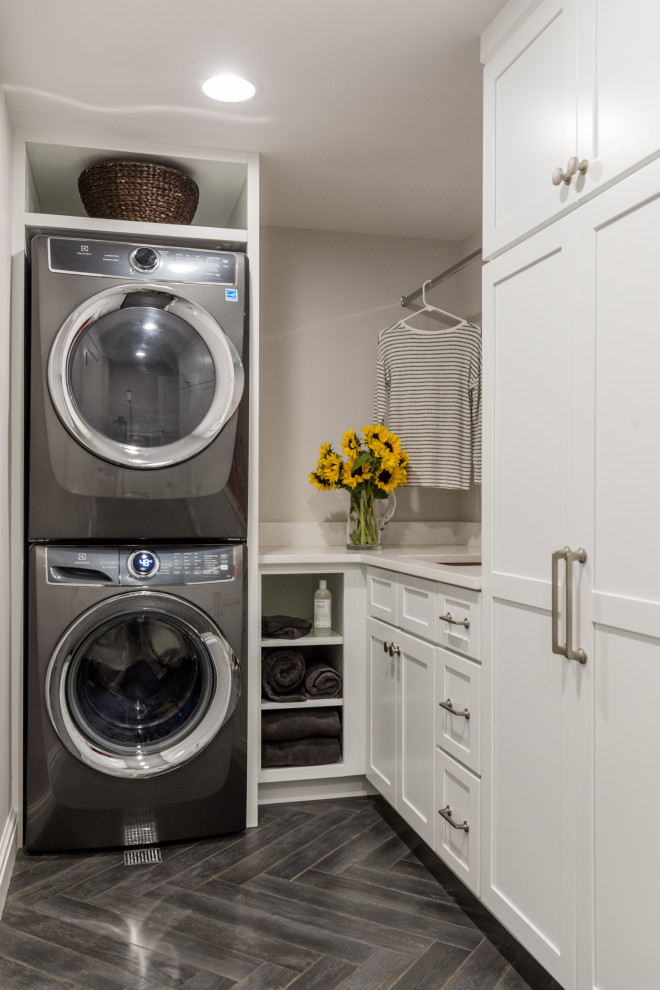 This is an example of a large transitional laundry room in Detroit with grey walls, laminate floors and brown floor.