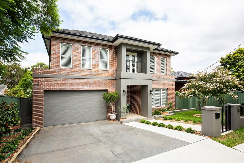 This is an example of a large transitional two-storey brick house exterior in Sydney with a tile roof.