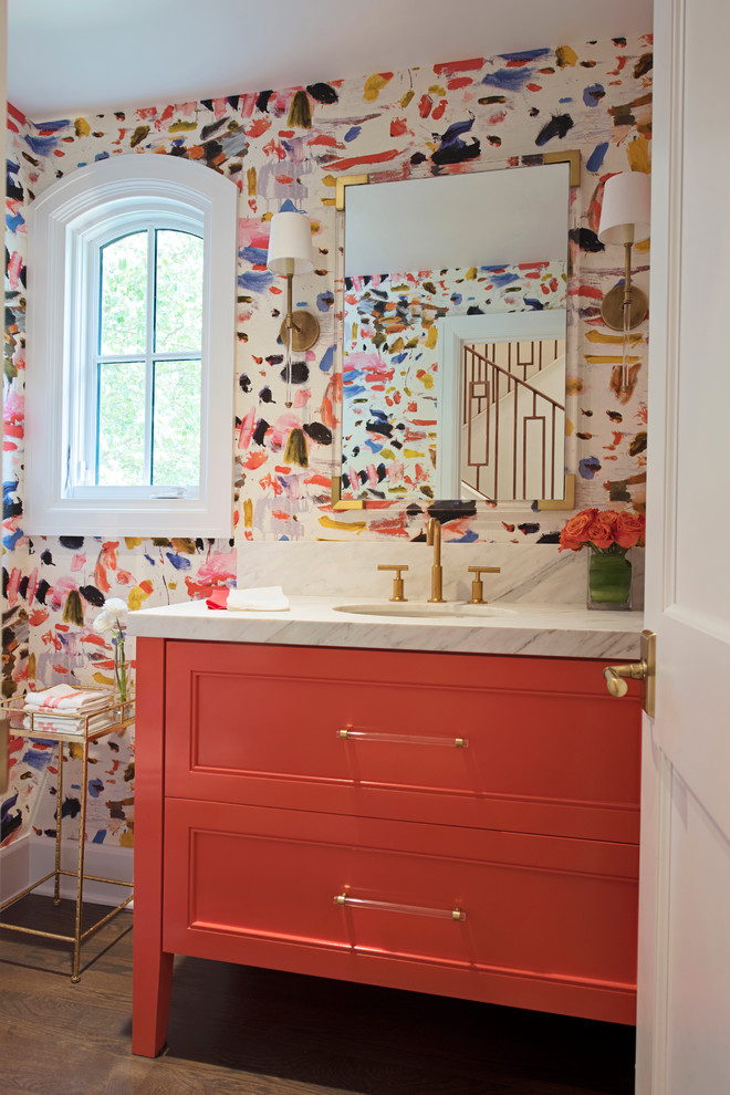 Inspiration for a mid-sized transitional powder room in Other with beaded inset cabinets, orange cabinets, multi-coloured walls, medium hardwood floors, an undermount sink, marble benchtops and brown floor.