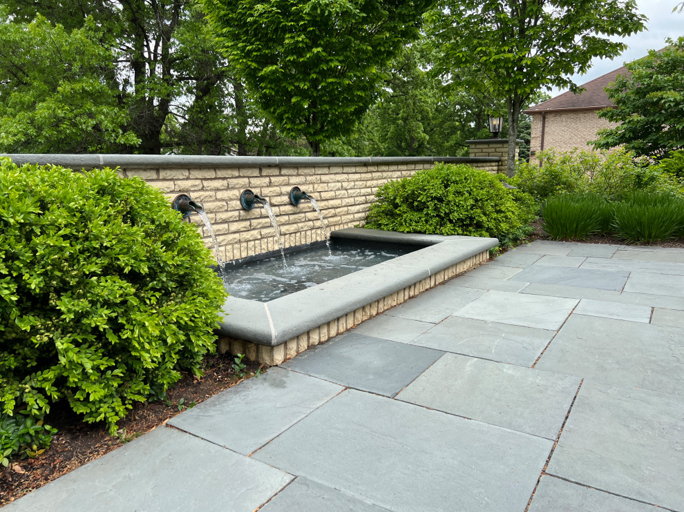Photo of a medium sized traditional front full sun garden for summer in Chicago with a waterfall and natural stone paving.