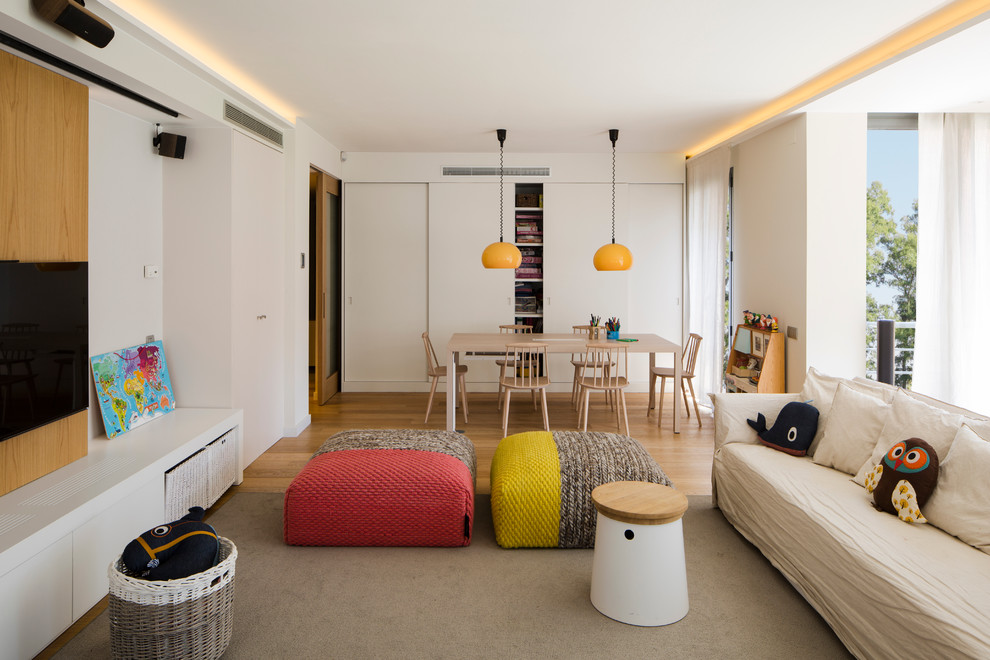Photo of a mid-sized scandinavian open concept family room in Barcelona with white walls, light hardwood floors, a wall-mounted tv and no fireplace.
