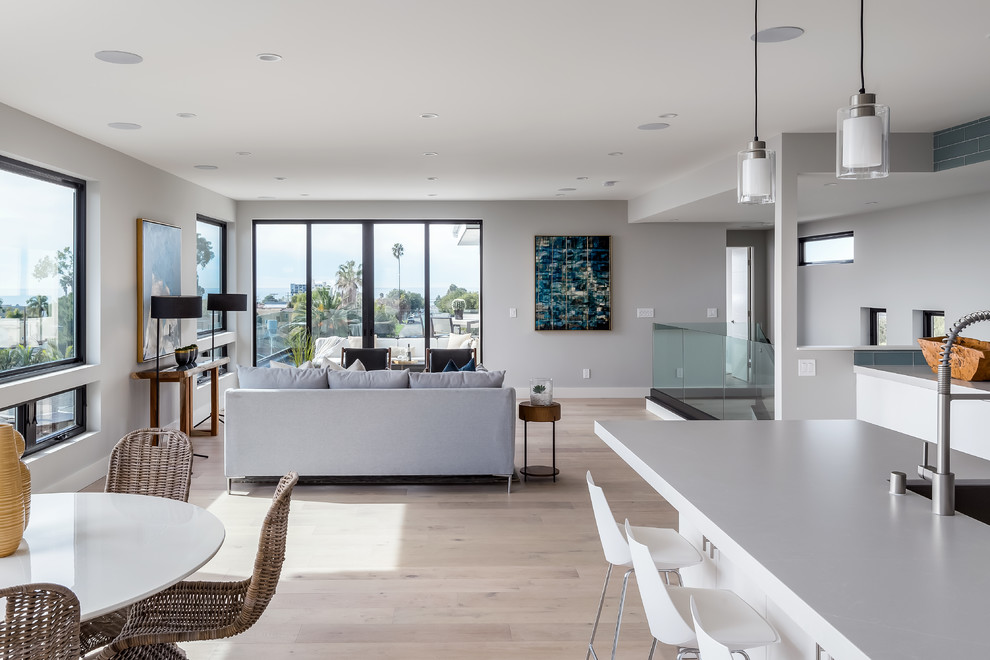 Photo of a large contemporary open concept family room in San Diego with grey walls, light hardwood floors and beige floor.