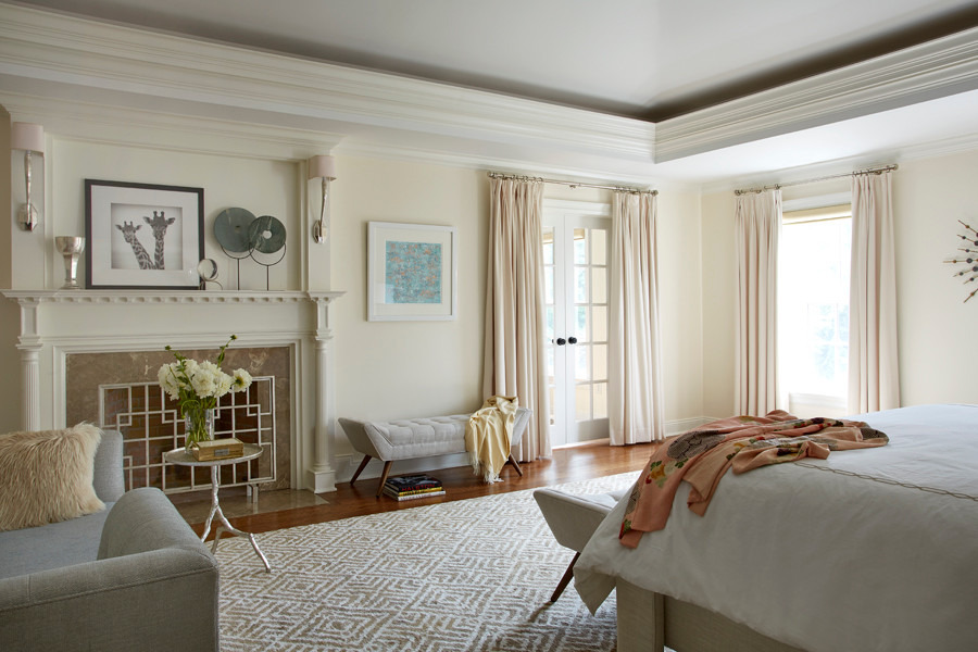 Inspiration for an expansive transitional master bedroom in New York with beige walls, medium hardwood floors, a standard fireplace and a stone fireplace surround.