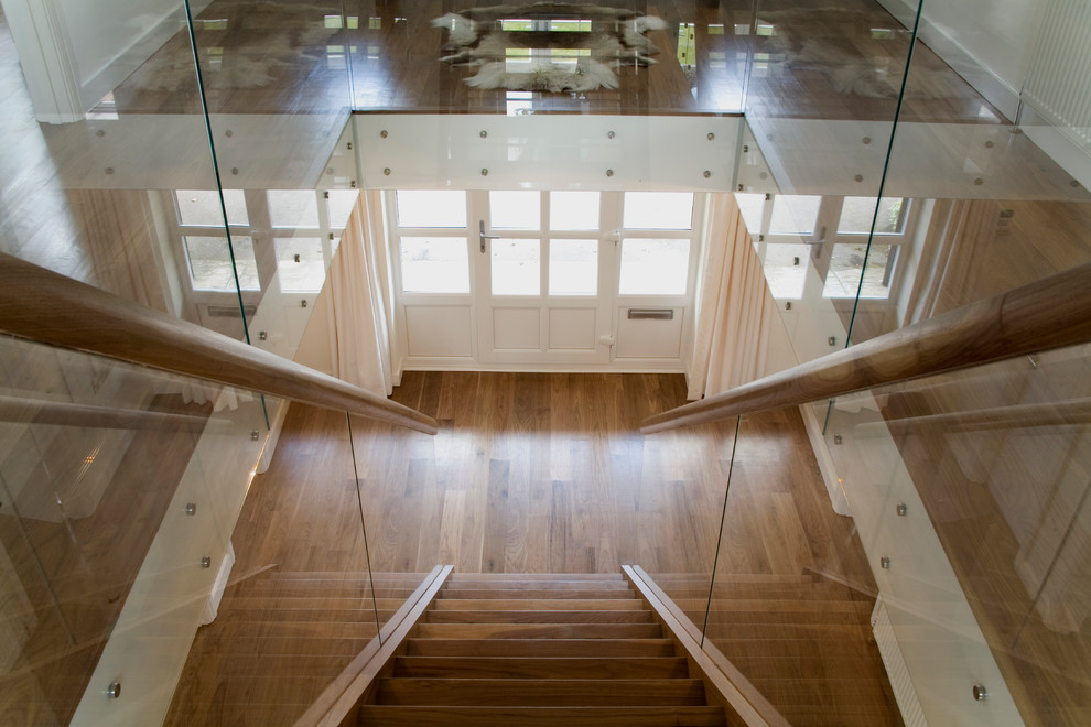 Mid-sized contemporary wood straight staircase in Sussex with wood railing.