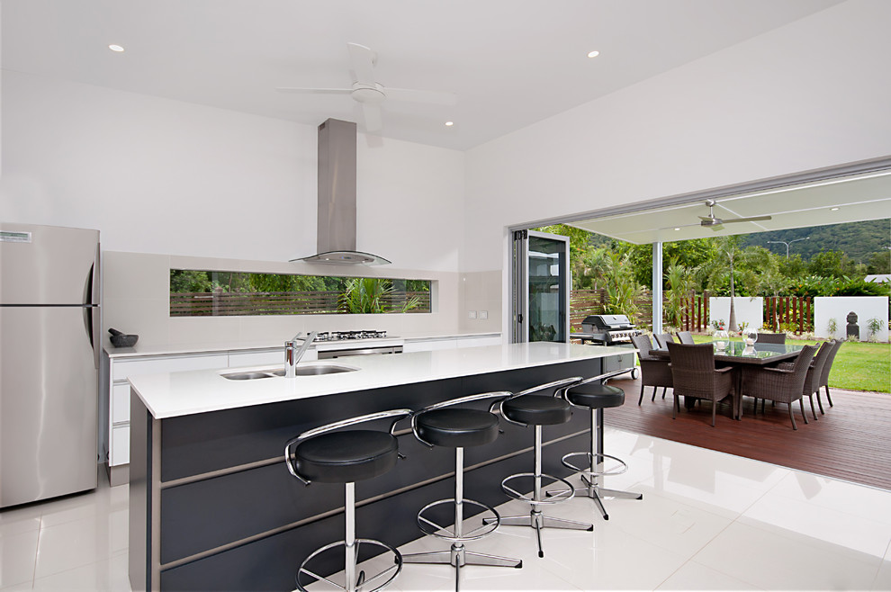 Photo of a mid-sized contemporary galley kitchen in Cairns with a double-bowl sink, quartzite benchtops, porcelain splashback, stainless steel appliances, porcelain floors and with island.