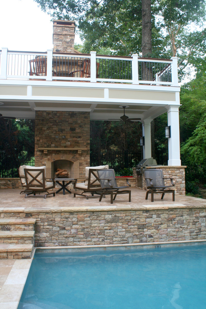 Large traditional backyard deck in Atlanta with with fireplace and a roof extension.