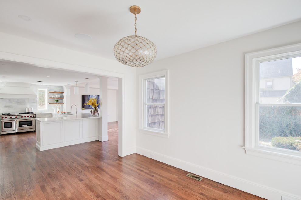 Mid-sized transitional u-shaped medium tone wood floor and brown floor open concept kitchen photo with a farmhouse sink, recessed-panel cabinets, white cabinets, quartz countertops, multicolored backsplash, marble backsplash, stainless steel appliances, a peninsula and white countertops
