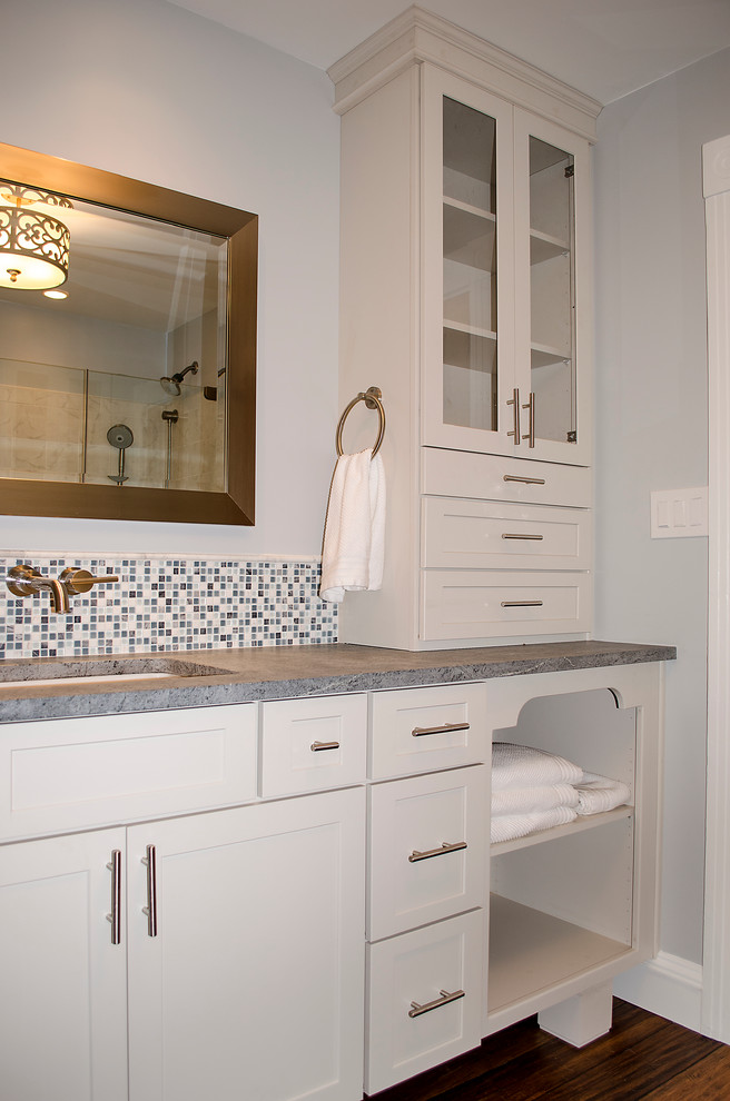 Inspiration for a mid-sized contemporary master bathroom in Philadelphia with an undermount sink, shaker cabinets, white cabinets, soapstone benchtops, a corner shower, a two-piece toilet, blue tile, glass tile, white walls and dark hardwood floors.