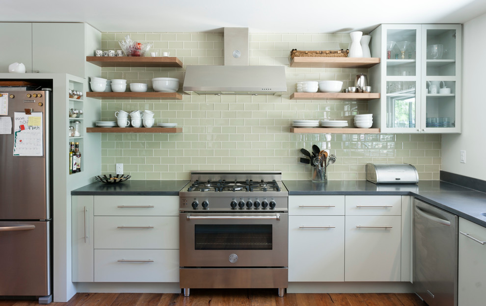 Photo of a contemporary kitchen in Austin with open cabinets, white cabinets, concrete benchtops, green splashback, glass tile splashback and stainless steel appliances.