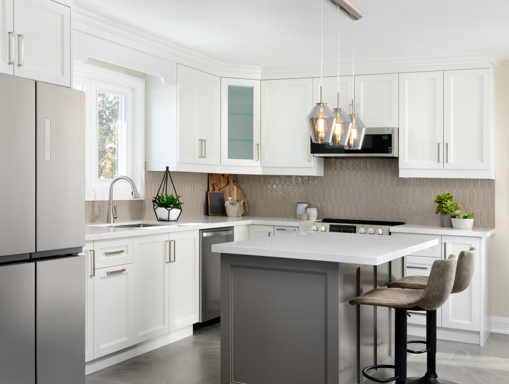 Mid-sized modern l-shaped eat-in kitchen in Toronto with an undermount sink, recessed-panel cabinets, white cabinets, quartz benchtops, beige splashback, porcelain splashback, stainless steel appliances, porcelain floors, with island, grey floor and white benchtop.