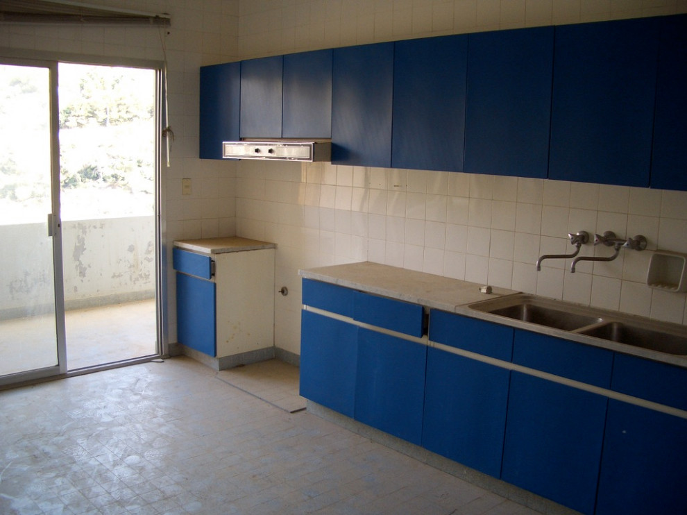 Example of a mid-sized minimalist galley enclosed kitchen design with flat-panel cabinets, laminate countertops and gray countertops