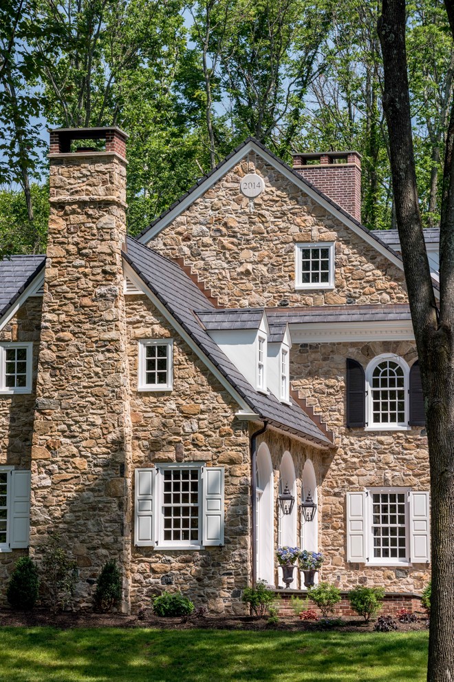 This is an example of a large traditional three-storey brown house exterior in Philadelphia with stone veneer, a gable roof and a shingle roof.
