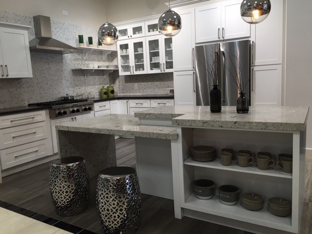 Mid-sized transitional l-shaped dark wood floor and gray floor enclosed kitchen photo in Orange County with white cabinets, gray backsplash, mosaic tile backsplash, stainless steel appliances, shaker cabinets, granite countertops and an island