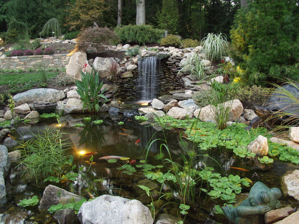 This is an example of a mid-sized asian backyard full sun garden in New York with a water feature and natural stone pavers.