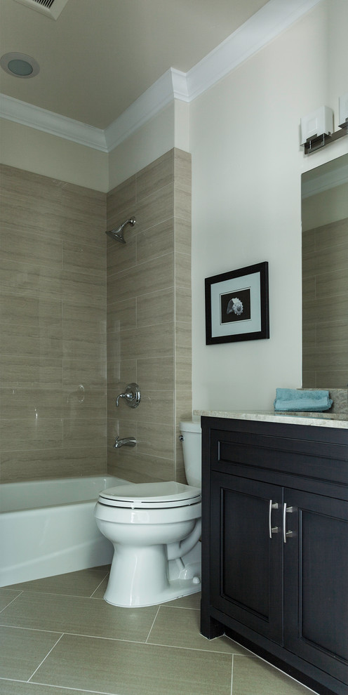 Mid-sized transitional 3/4 bathroom in San Francisco with shaker cabinets, beige walls, limestone floors, an undermount sink, black cabinets, an alcove tub, a shower/bathtub combo, a two-piece toilet, stone tile and granite benchtops.