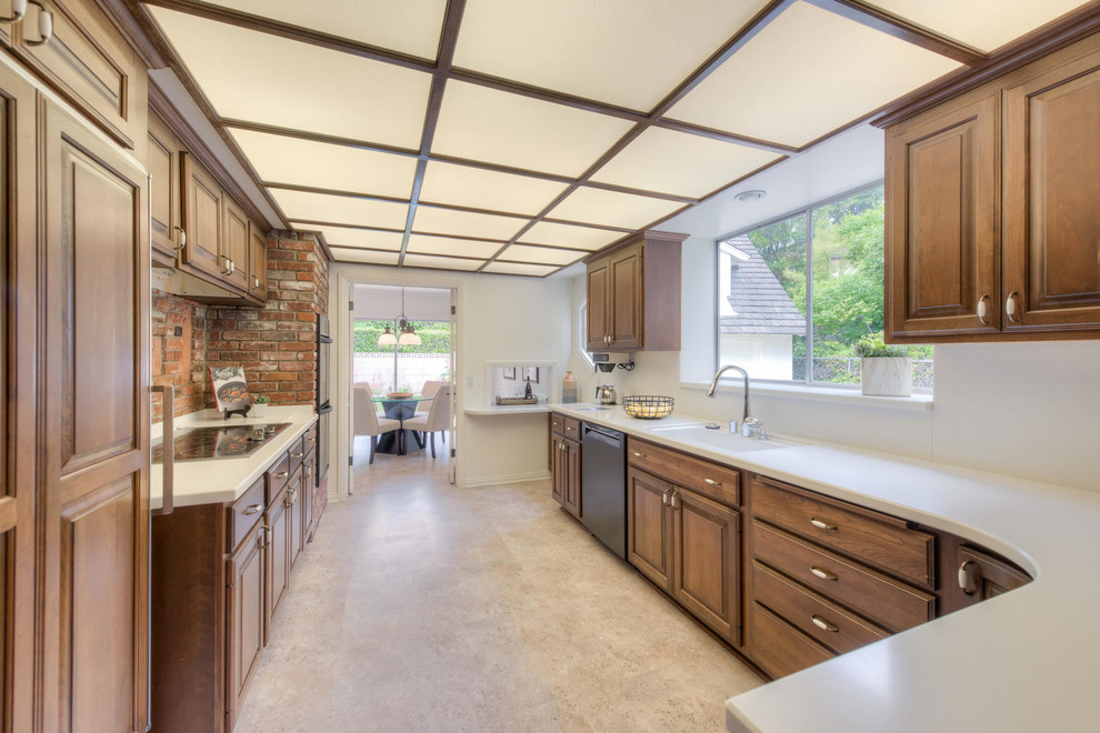Inspiration for a mid-sized traditional galley eat-in kitchen in Los Angeles with raised-panel cabinets, medium wood cabinets, solid surface benchtops, stainless steel appliances, vinyl floors, no island and beige floor.