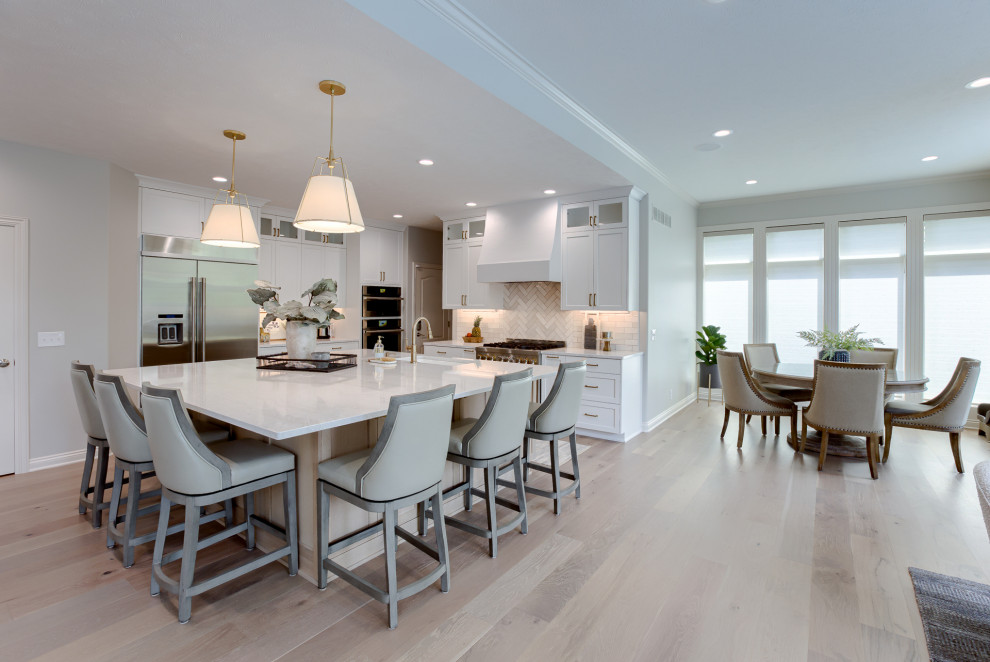 Inspiration for a transitional light wood floor and beige floor open concept kitchen remodel with an undermount sink, white cabinets, quartzite countertops, multicolored backsplash, stainless steel appliances and an island