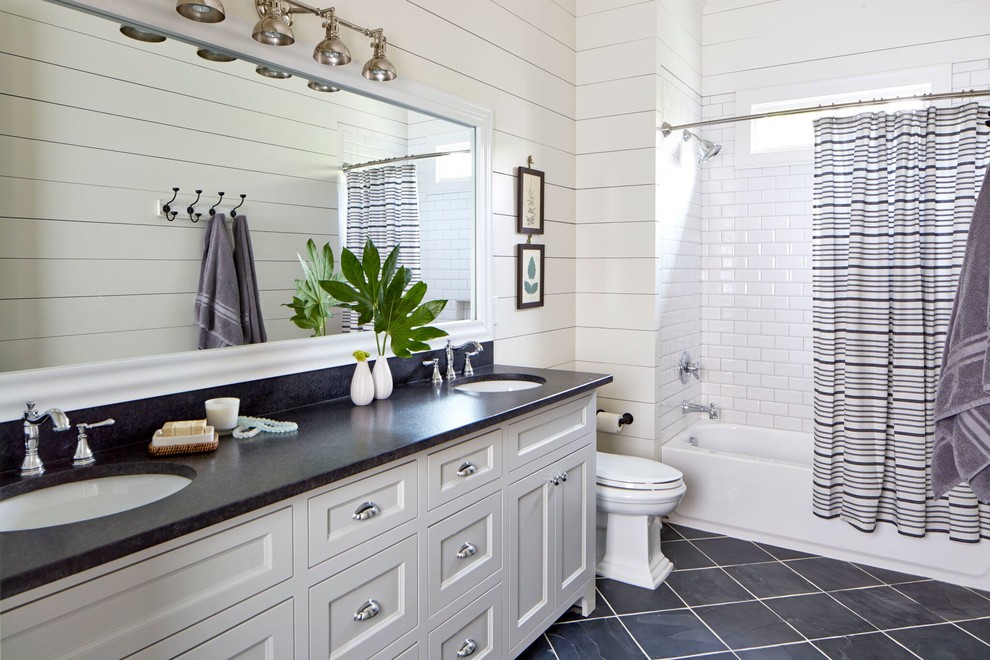 Inspiration for a mid-sized country bathroom in Atlanta with shaker cabinets, white cabinets, a shower/bathtub combo, a one-piece toilet, white tile, subway tile, white walls, slate floors, an undermount sink and marble benchtops.