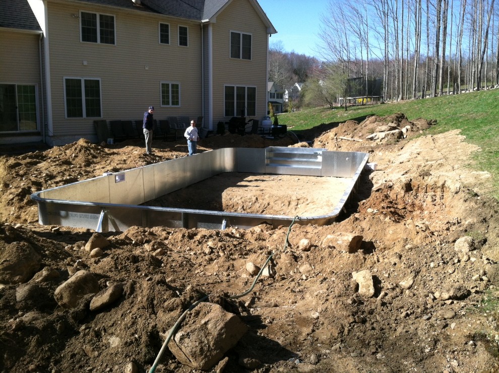 Example of a mid-sized backyard brick and rectangular pool design