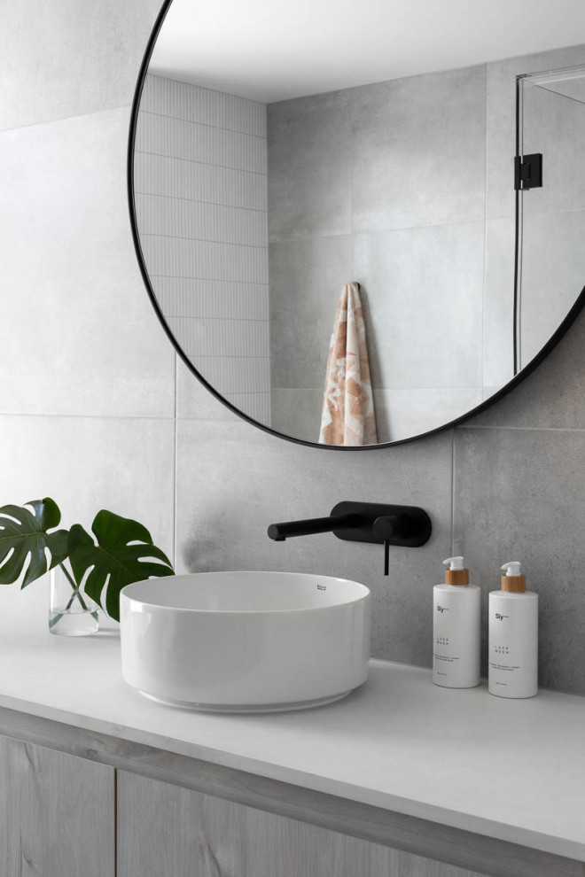 Photo of a mid-sized contemporary master bathroom in Melbourne with ceramic tile, a vessel sink, white benchtops, a single vanity, flat-panel cabinets, engineered quartz benchtops, grey cabinets and gray tile.