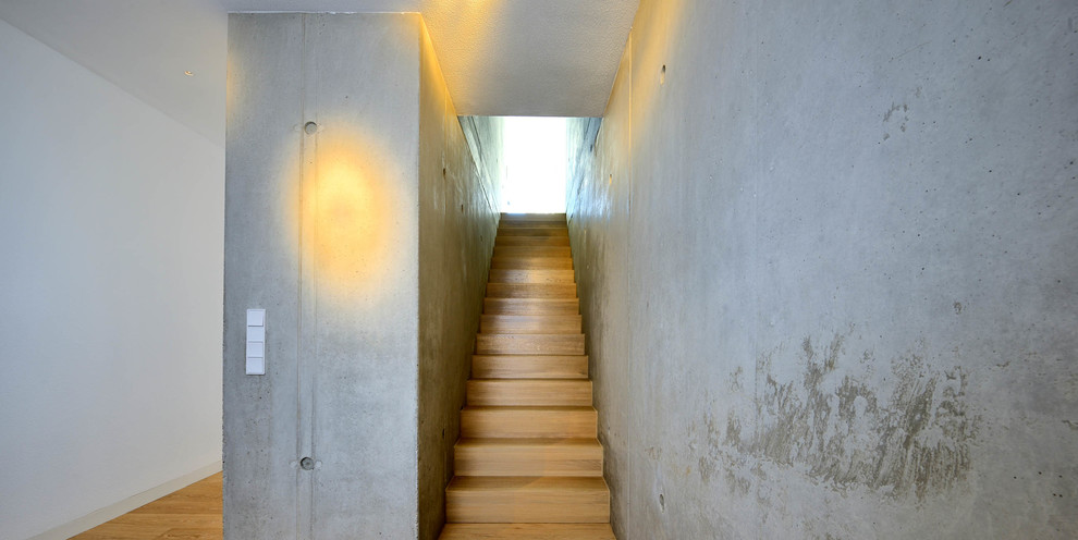 Photo of a mid-sized industrial wood straight staircase in Munich with wood risers.