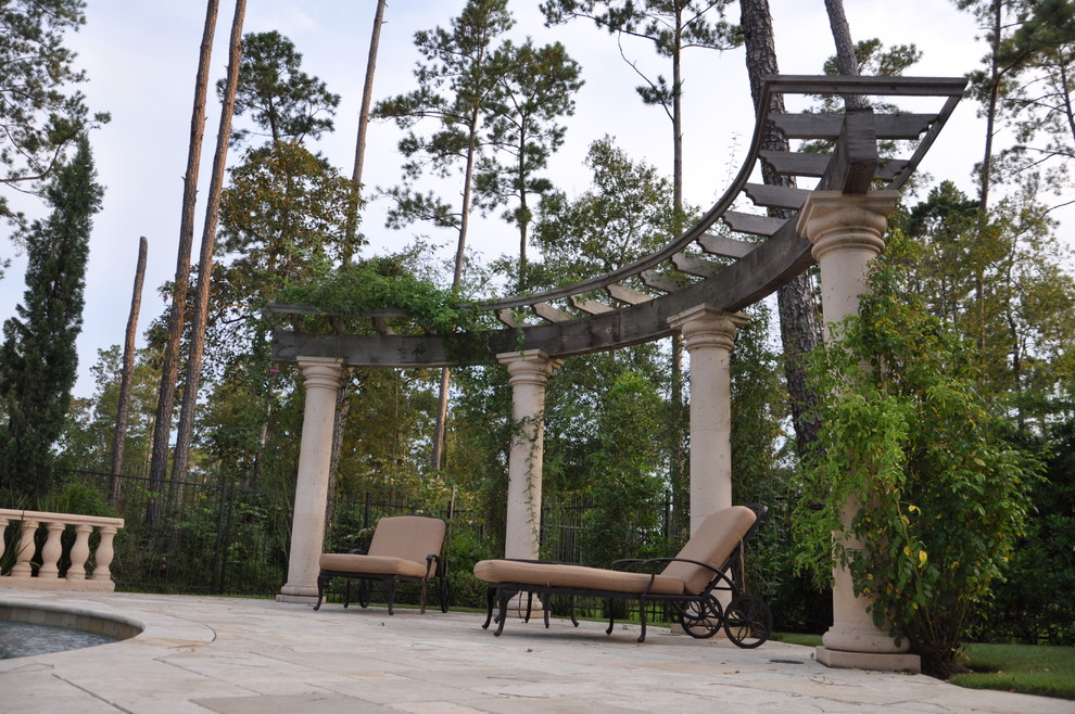 This is an example of a mid-sized mediterranean backyard deck in Houston with a water feature and a pergola.