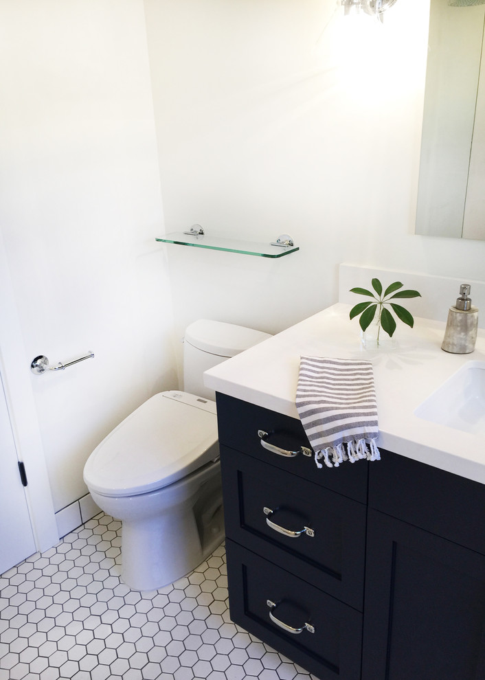 This is an example of a mid-sized transitional master wet room bathroom in Santa Barbara with shaker cabinets, blue cabinets, a japanese tub, white tile, porcelain tile, white walls, porcelain floors, an undermount sink, engineered quartz benchtops and a bidet.
