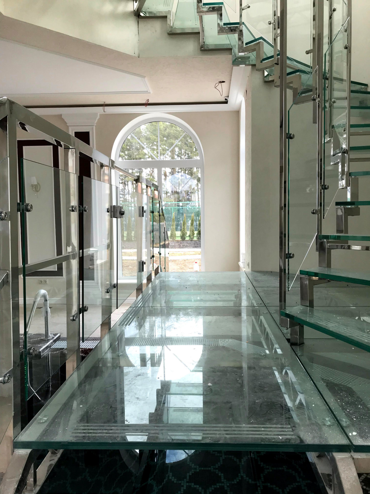 Винтовая стеклянная лестница над бассейном