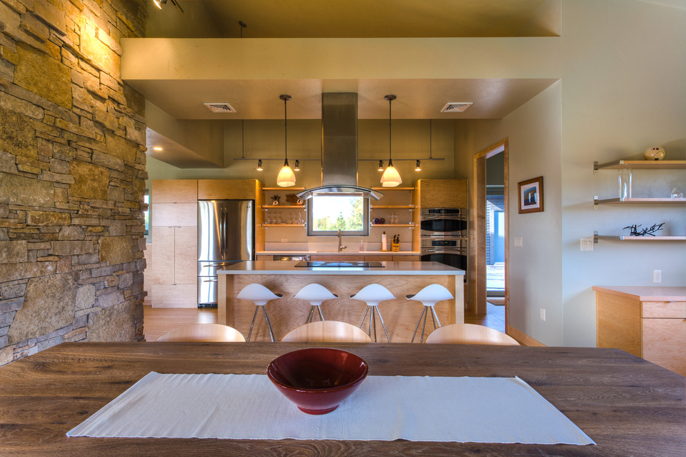 Eat-in kitchen - mid-sized contemporary galley medium tone wood floor eat-in kitchen idea with a drop-in sink, flat-panel cabinets, light wood cabinets, marble countertops, stainless steel appliances and an island