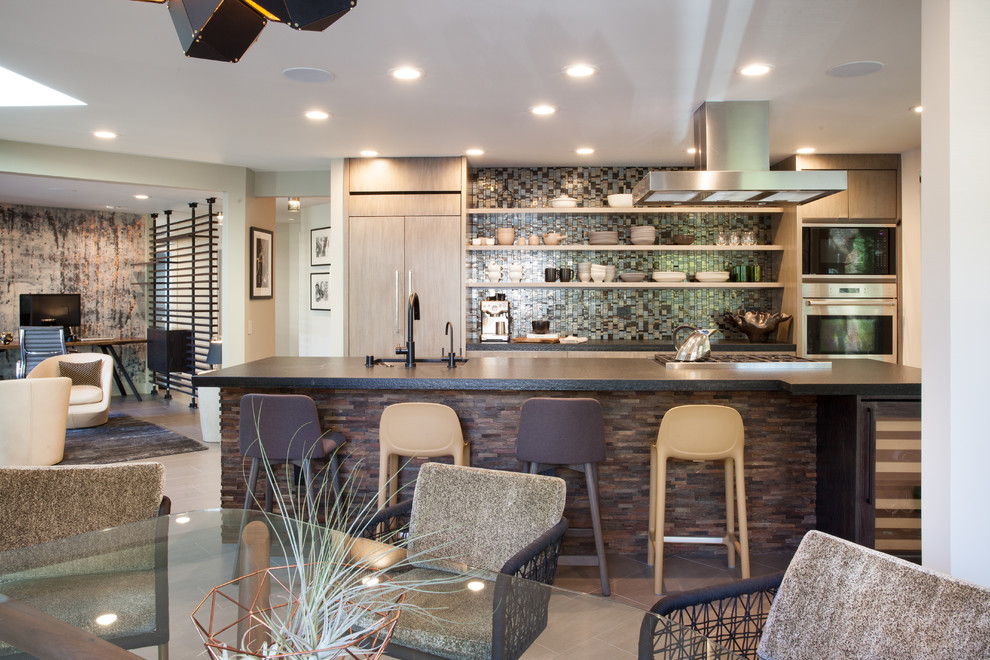 This is an example of a mid-sized modern galley eat-in kitchen in San Francisco with an undermount sink, flat-panel cabinets, medium wood cabinets, glass tile splashback, stainless steel appliances, porcelain floors, with island, brown floor and black benchtop.